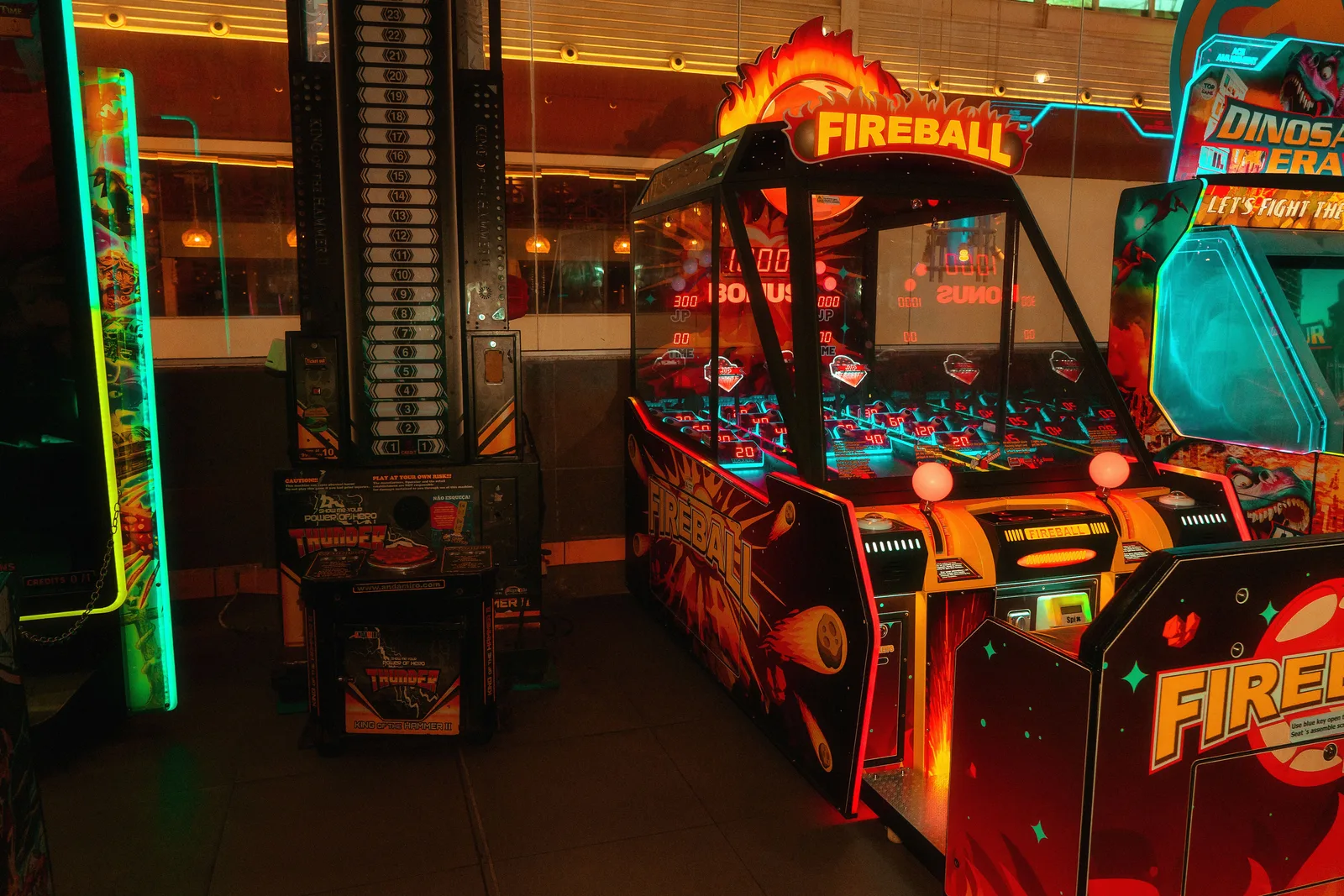 Arcade machines glowing with neon lights in a dark game room
